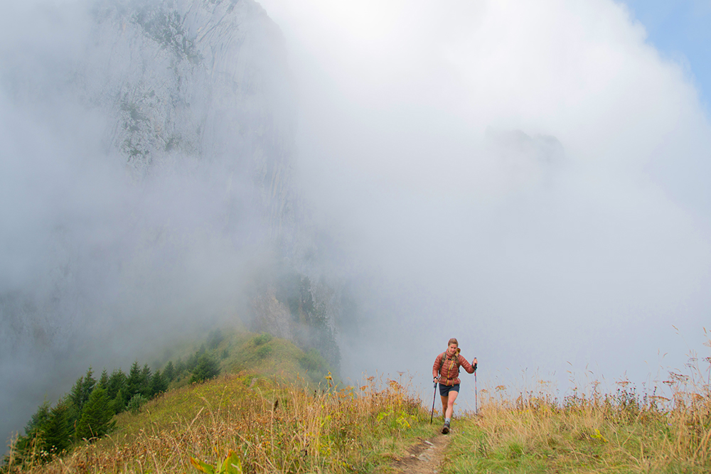 A woman is hiking with trekking poles