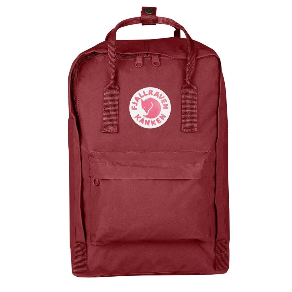 burgundy/deep red rectangular backpack with tonal webbing carry handles, a lower-front zip pocket and two-way zipper pulls at the main compartment; a white and red Fjallraven fox logo patch it featured at the front
