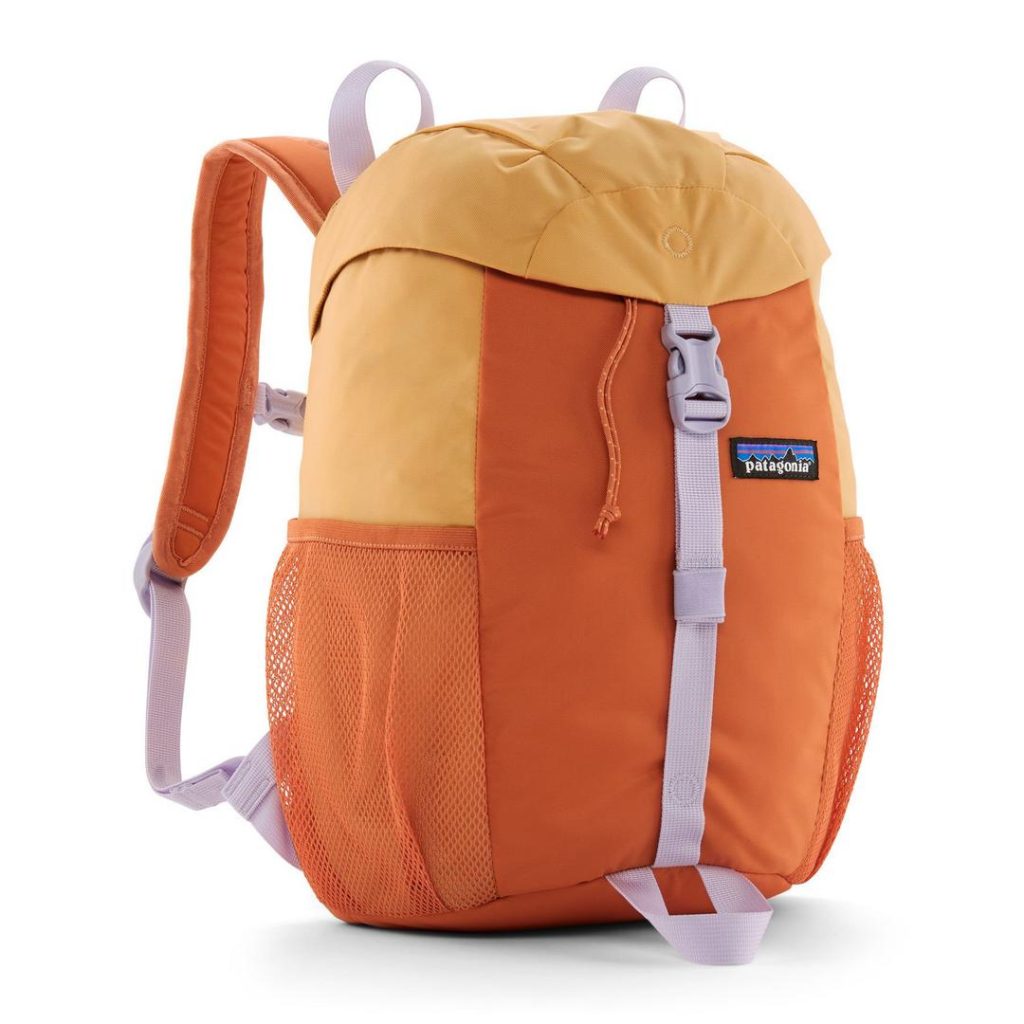 small two-tone orange canvas backpack with contrast lilac trim at the front webbing buckled strap, bottom carry loop and the adjustable webbing at the bottom of the orange shoulder straps; it has stretchy mesh side water bottle pockets and a Patagonia logo patch at the front-right side