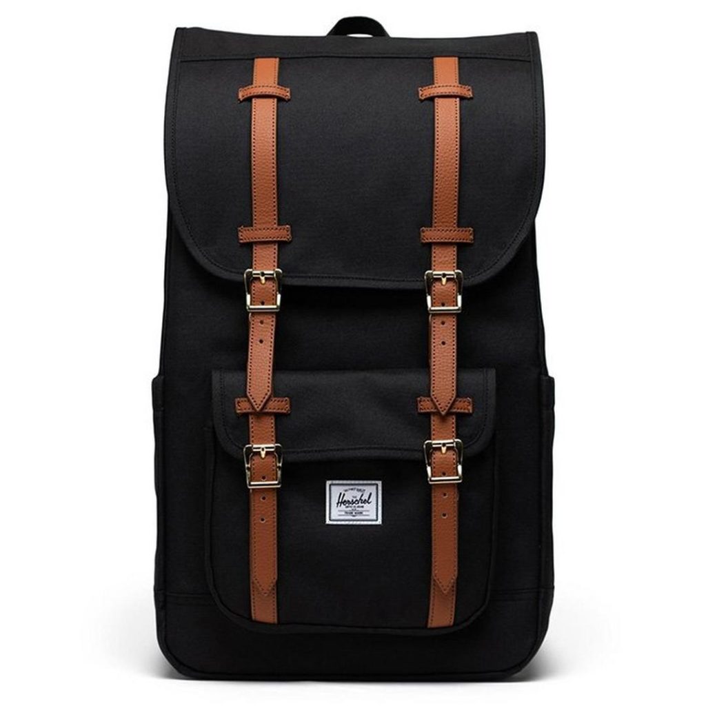 black rectangular backpack with four contrast brown leather straps down the front; each strap includes a metal pin-buckle closure; there is a small lower-front pocket with buckled flap closure and a contrast white woven Herschel logo patch at the centre